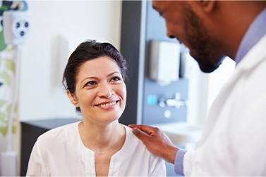 Male doctor comforting female patient.