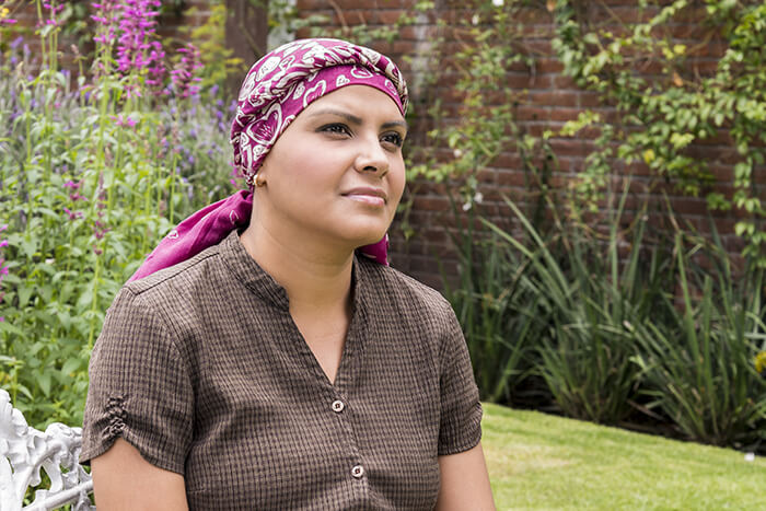 Female patient sitting thoughtfully outside.