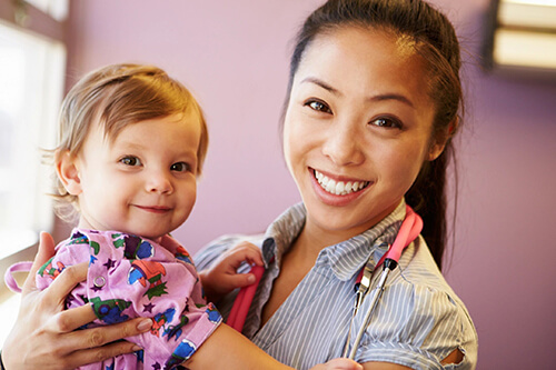 Health professional holding toddler.